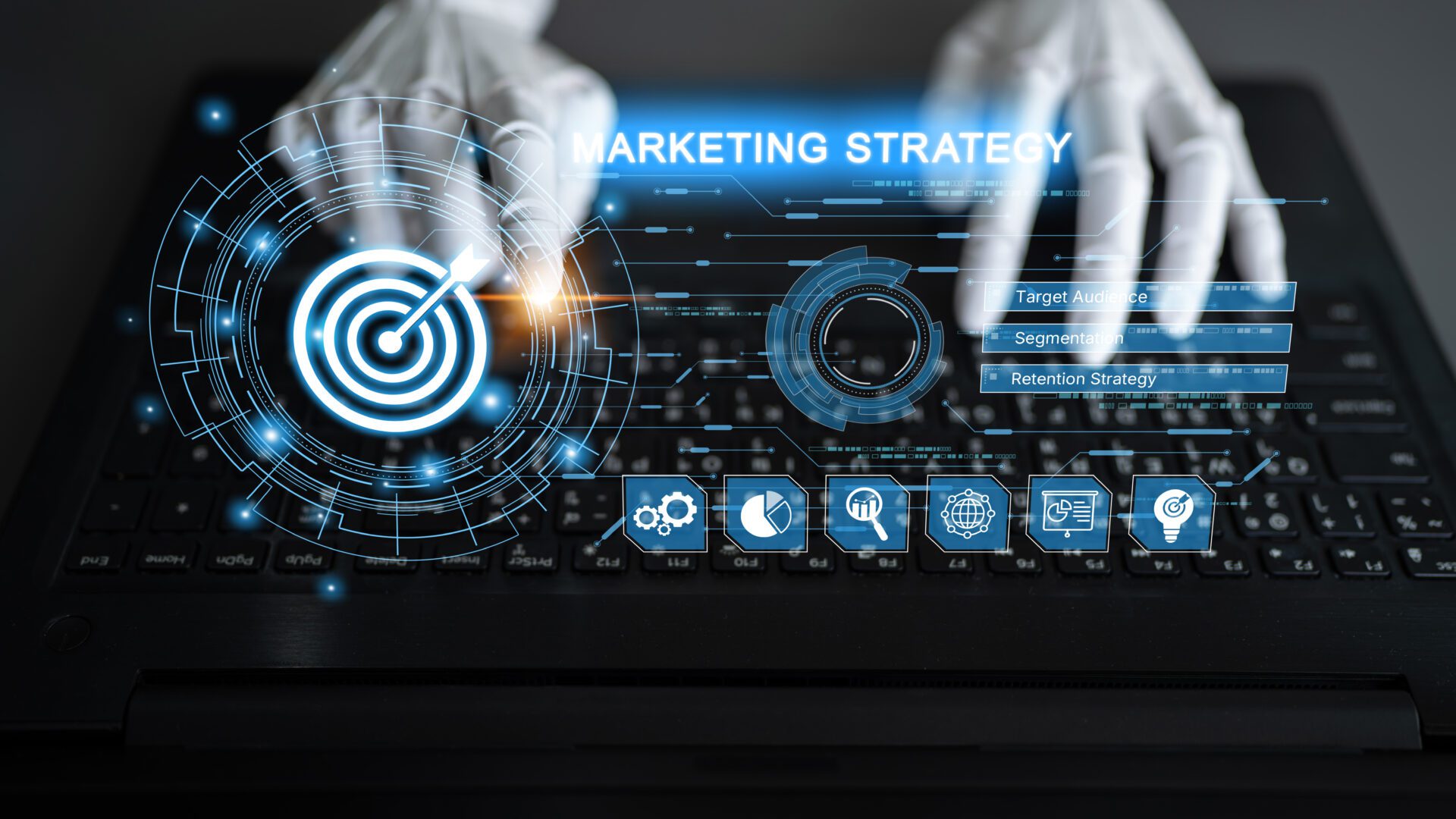 A person’s hands typing on a laptop keyboard, with glowing digital overlays displaying a marketing strategy and targets.